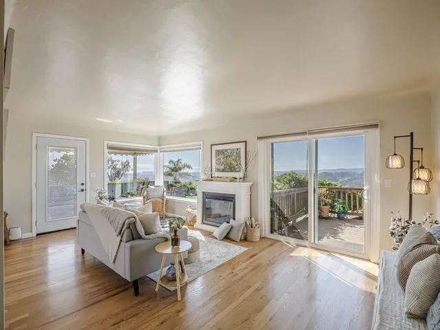 a living room with furniture large window and wooden floor