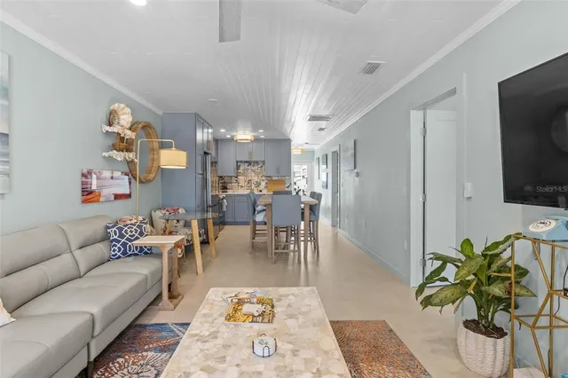 a living room with furniture and a view of kitchen