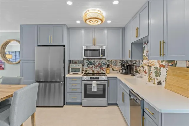 a kitchen with stainless steel appliances granite countertop a refrigerator stove and sink