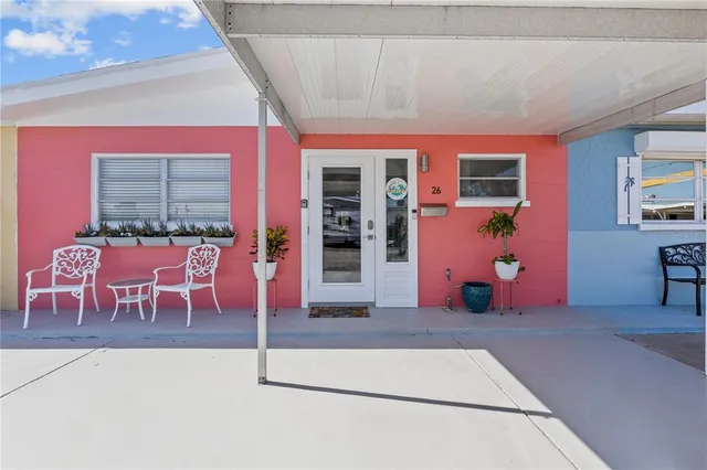 a view of swimming pool with lawn chairs and wooden fence