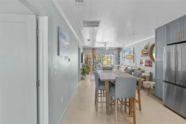 a dining hall with stainless steel appliances granite countertop a stove a sink dishwasher and cabinets with wooden floor