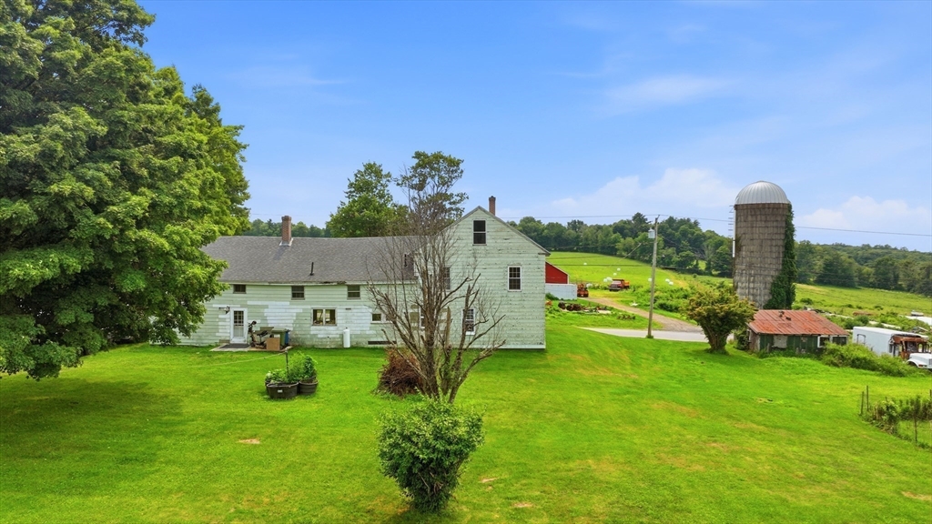 233 Ragged Hill Road West Brookfield, MA 01585 - Photo 5 of 42 a view of a house with a big yard potted plants and a large tree