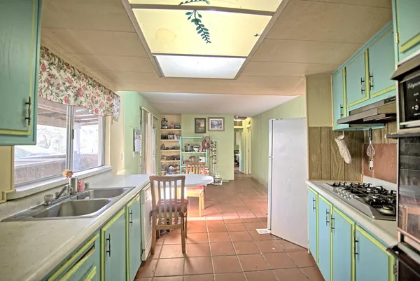 a kitchen with stainless steel appliances a sink stove and refrigerator