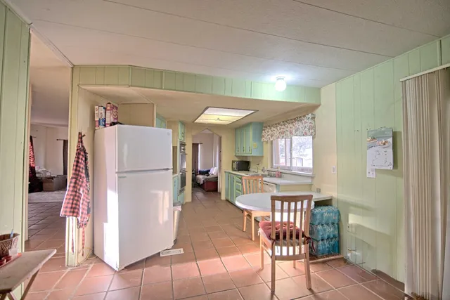 a view of kitchen with furniture and refrigerator