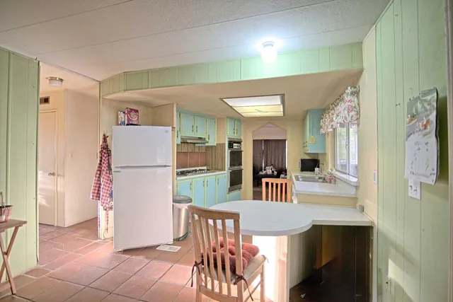 a dining room with furniture and a refrigerator