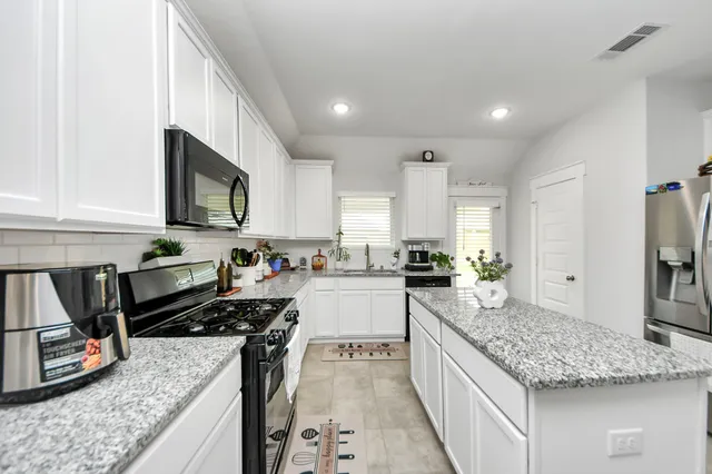 a kitchen with stainless steel appliances granite countertop a sink stove and refrigerator