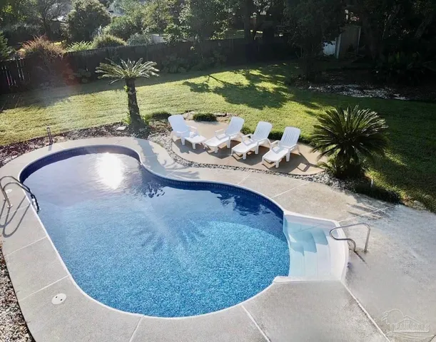 a view of a swimming pool with a yard and sitting space