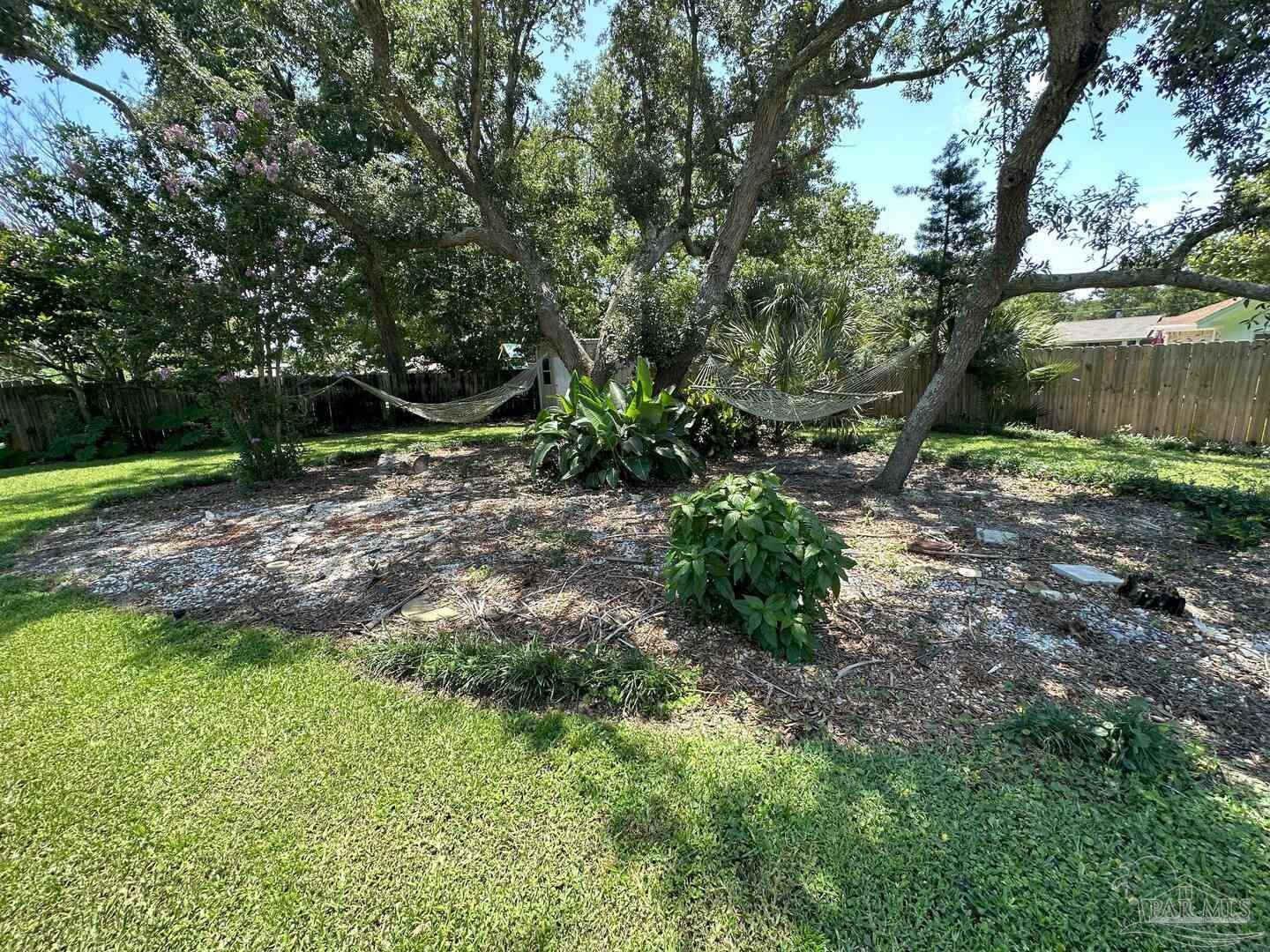 1406 Rancho Villa Drive Gulf Breeze, FL 32563 - Photo 17 of 19 a view of a backyard with large trees