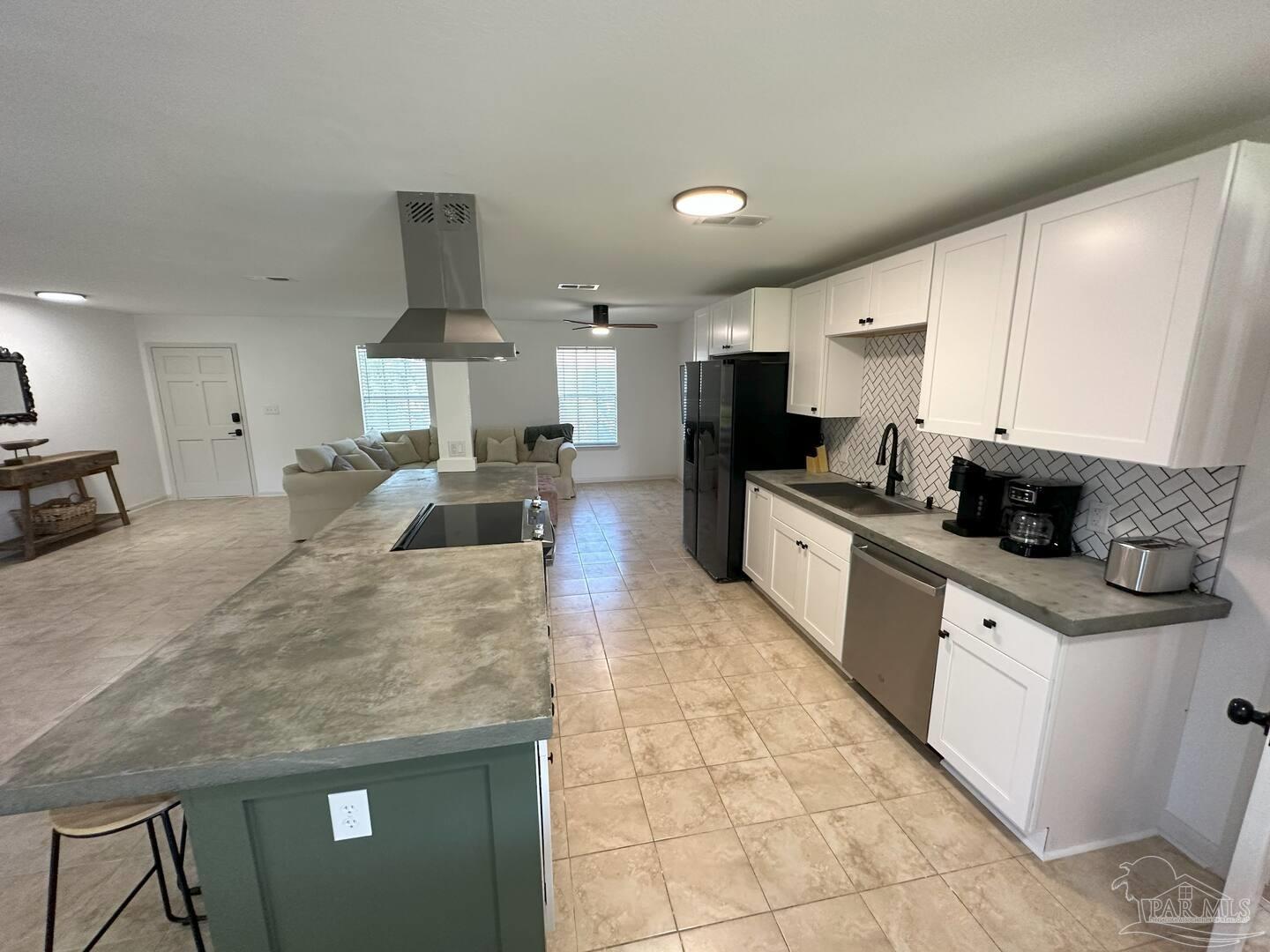 1406 Rancho Villa Drive Gulf Breeze, FL 32563 - Photo 5 of 19 a large kitchen with stainless steel appliances kitchen island granite countertop a sink a stove and cabinets