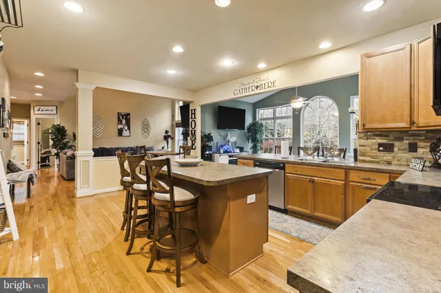 a kitchen with stainless steel appliances granite countertop sink stove and wooden cabinets