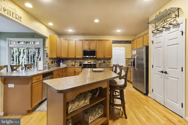 a kitchen with kitchen island granite countertop a sink a counter top stainless steel appliances cabinets and a counter top space