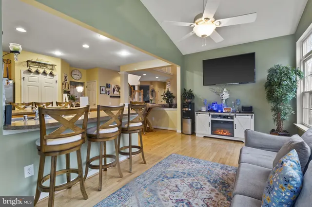 a living room with furniture a flat screen tv and kitchen view