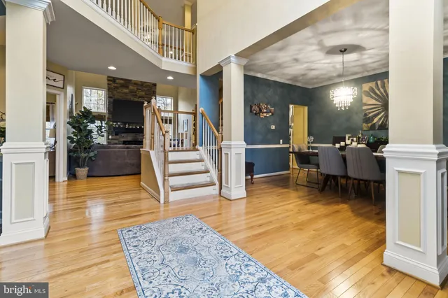 a living room with furniture and a dining table with wooden floor