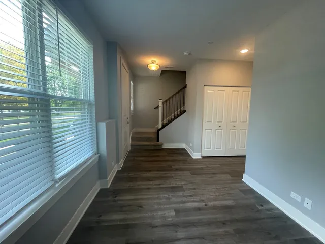 a view of a hallway with wooden floor and staircase