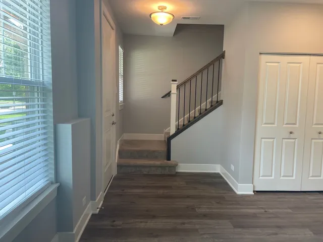 a view of entryway and hall with wooden floor