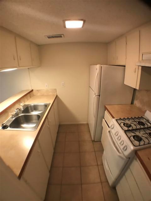 2610 Salado Street, Unit 105 Austin, TX 78705 - Photo 6 of 11 a kitchen with a sink a stove and a refrigerator