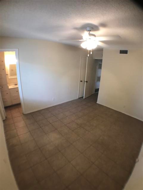 2610 Salado Street, Unit 105 Austin, TX 78705 - Photo 7 of 11 an empty room with a chandelier fan and windows