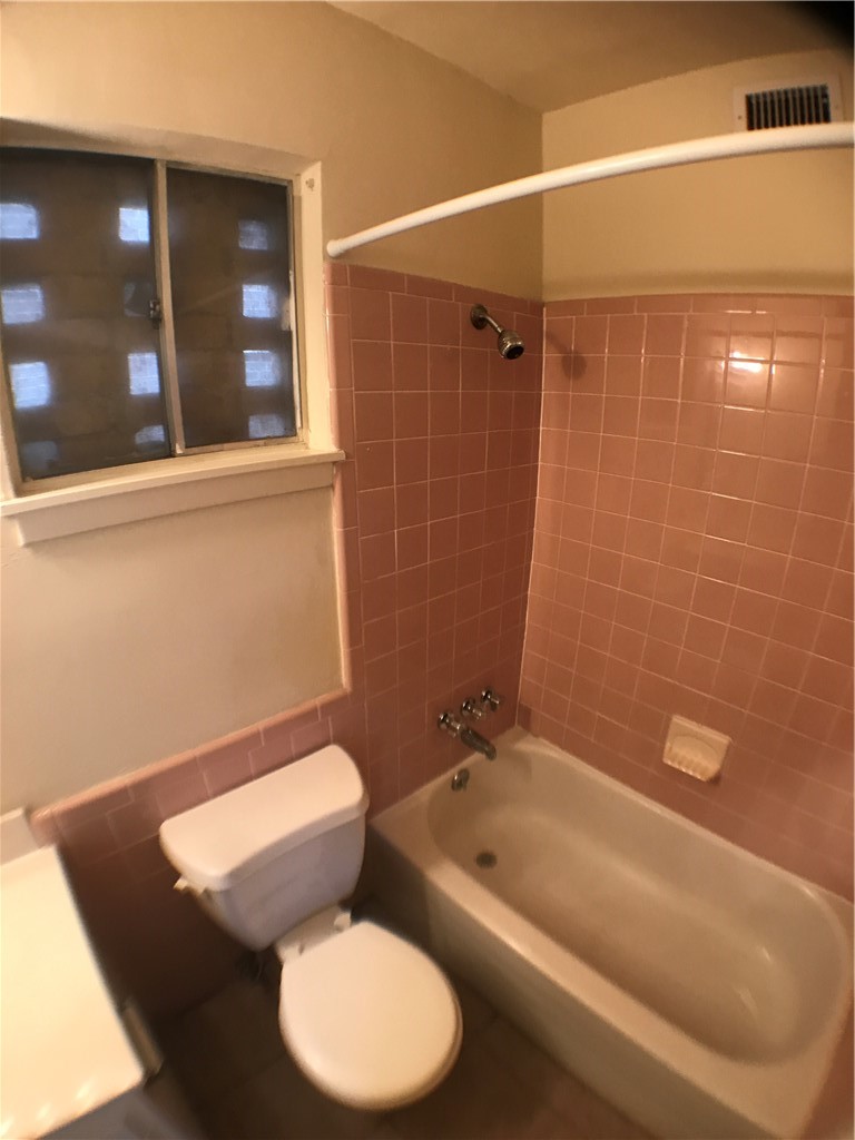 2610 Salado Street, Unit 105 Austin, TX 78705 - Photo 9 of 11 a bathroom with a toilet and a bathtub