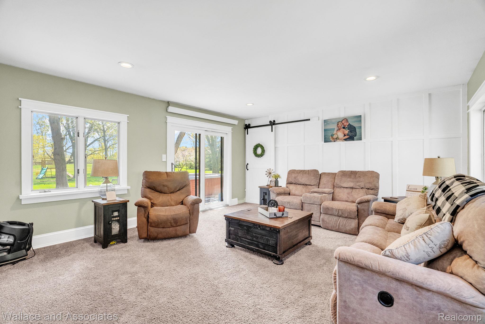 6616 Wellman Line Road Croswell, MI 48422 - Photo 22 of 47 Carpeted living room with a barn door, recessed lighting, and a decorative wall