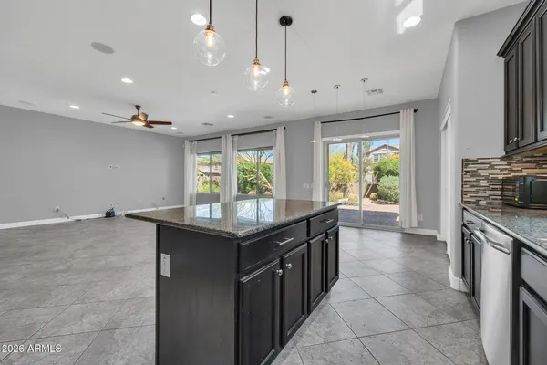 a kitchen with stainless steel appliances granite countertop a sink a stove and a wooden floors