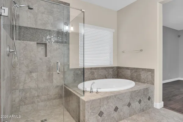 a bathroom with a tub a window and a shower