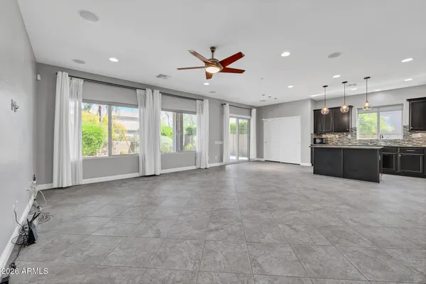 a view of an empty room with a kitchen stove and kitchen view