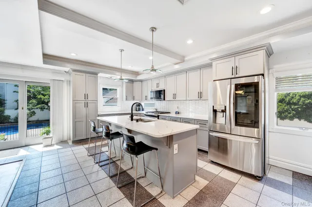 a kitchen with stainless steel appliances a sink a stove a refrigerator and cabinets