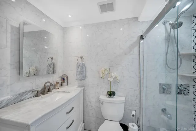 a bathroom with a granite countertop sink toilet and shower