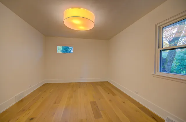 a view of a room with wooden floor and a window