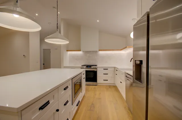 a kitchen with stainless steel appliances granite countertop a sink a stove and a refrigerator