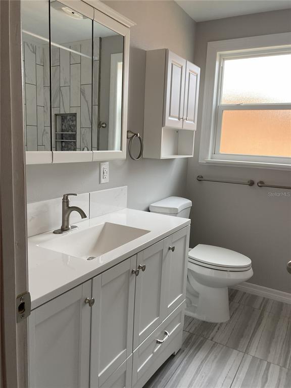 14033 Palm Street Madeira Beach, FL 33708 - Photo 25 of 41 a bathroom with a toilet sink and mirror