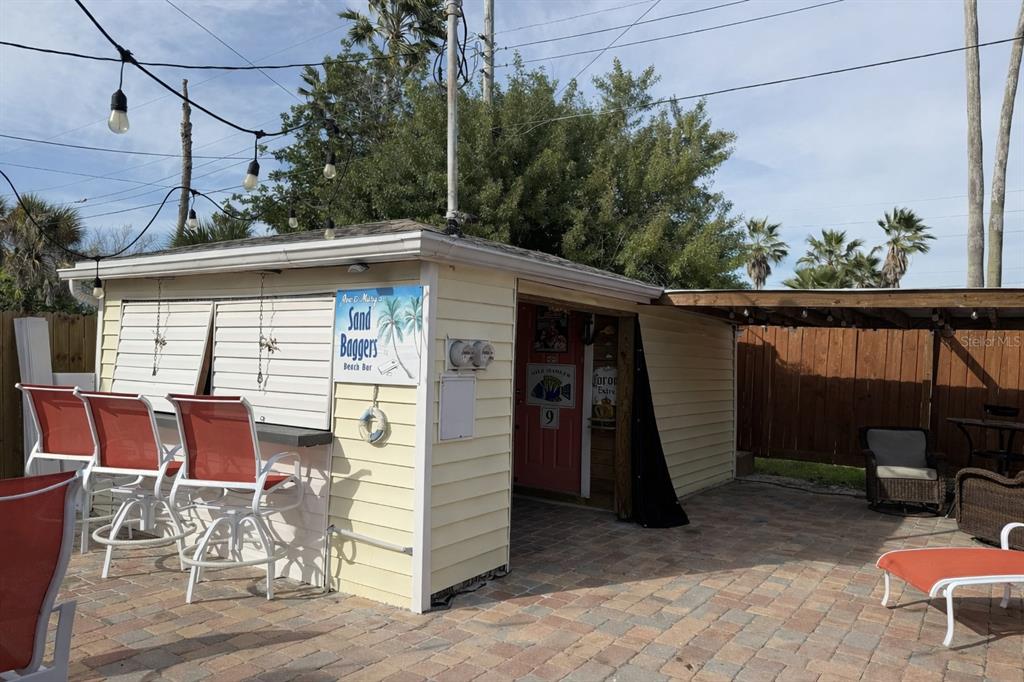 14033 Palm Street Madeira Beach, FL 33708 - Photo 35 of 41 a view of a patio with table and chairs with wooden fence