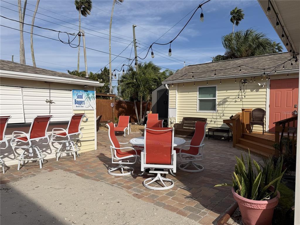 14033 Palm Street Madeira Beach, FL 33708 - Photo 37 of 41 a view of a patio with table and chairs and potted plants