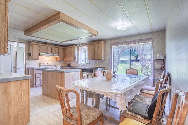 a kitchen with a dining table chairs and chandelier