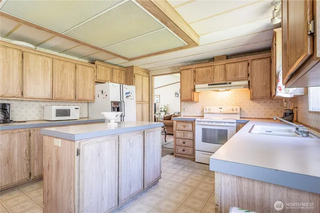 a kitchen with a stove sink cabinets and wooden floor