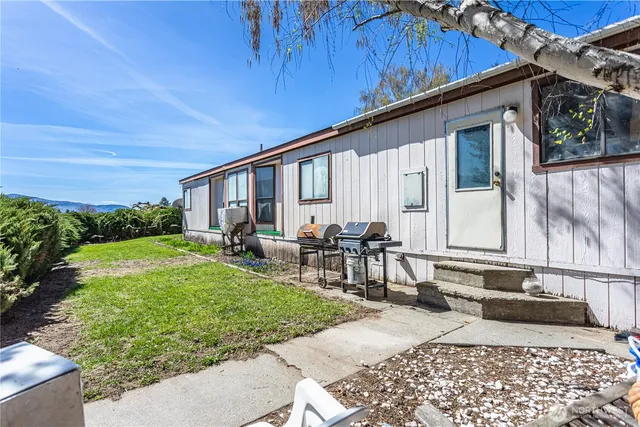 a backyard of a house with garden and outdoor seating