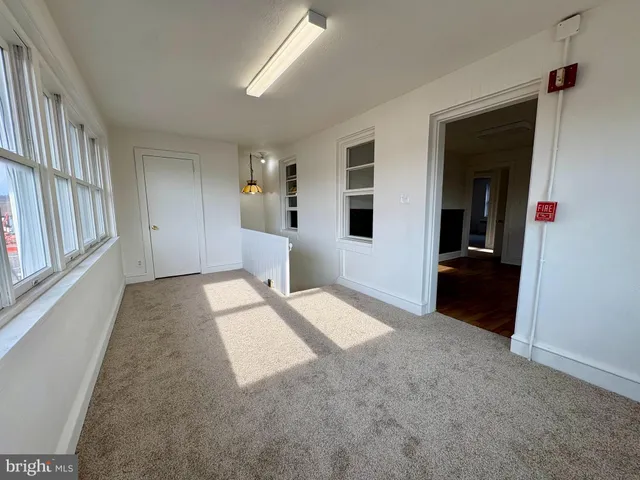 a view of a hallway with wooden floor and windows