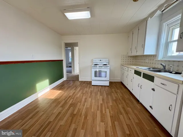 a kitchen with stainless steel appliances hardwood floor sink and stove