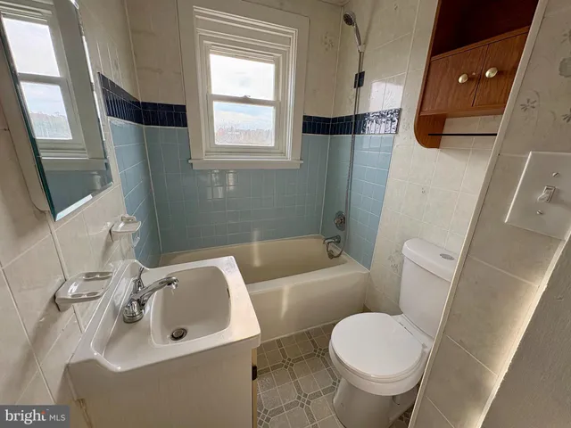 a white toilet sitting next to a bathroom sink and tub