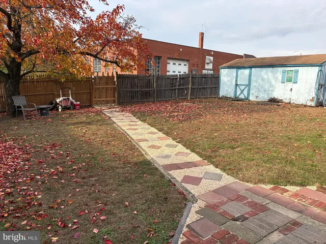 a backyard of a house with a basket ball court and trees