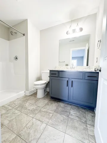 a bathroom with a granite countertop sink a toilet and a mirror