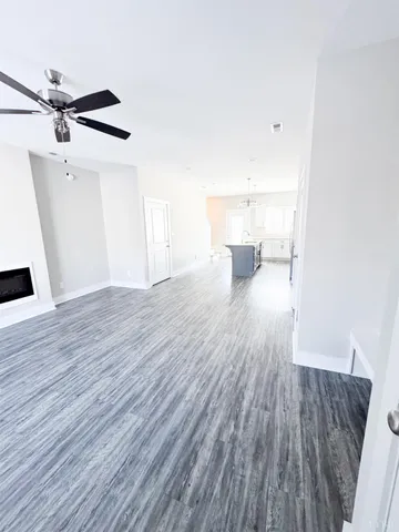 a view of a living room hardwood floor and a ceiling fan