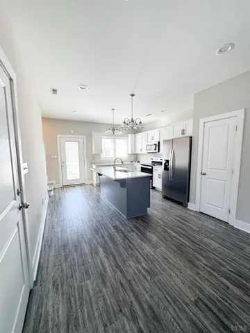 a view of a kitchen with wooden floor and electronic appliances