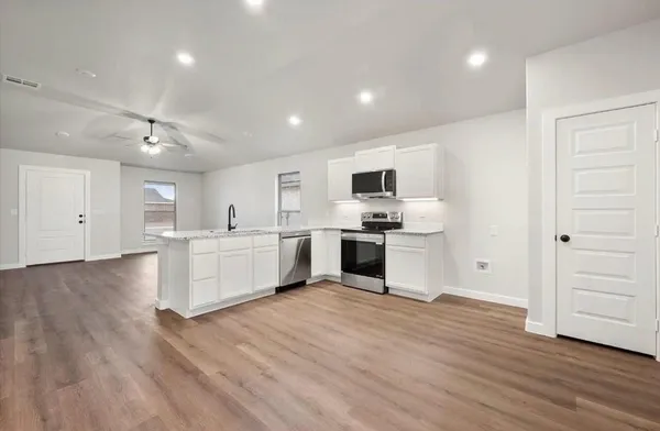 a view of an empty room with wooden floor