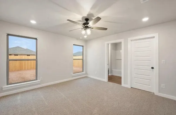 an empty room with closet and fan