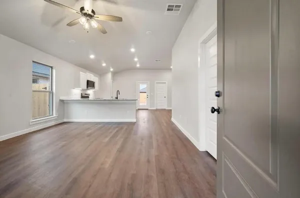 a view of a kitchen with wooden floor and a kitchen