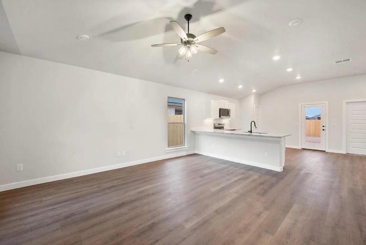 1708 145th Street Lubbock, TX 79423 - Photo 3 of 19 a view of an empty room with wooden floor and a ceiling fan
