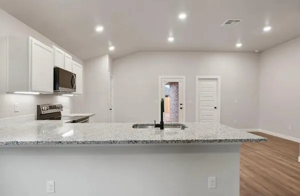 a kitchen with sink refrigerator and microwave