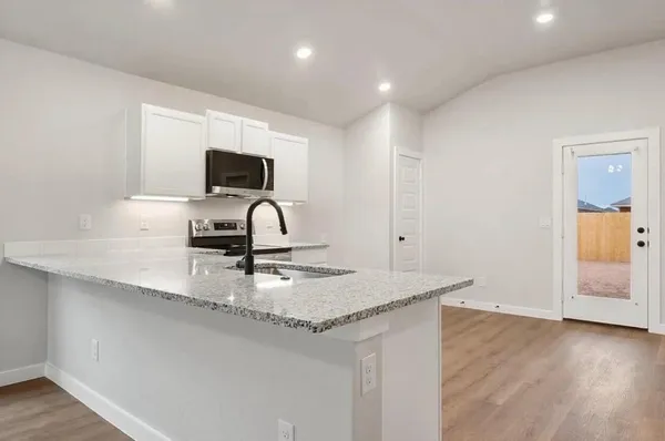 a kitchen with stainless steel appliances granite countertop a sink and a stove top oven