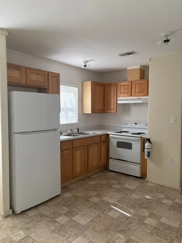 a kitchen with a refrigerator stove top oven and sink